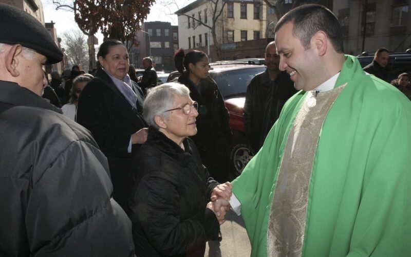 Pastor greets parish staff and others